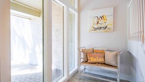 A modern interior with a bench, a painting, and large windows. - In the Heart of Harbour Town!  Gorgeous, End Unit Townhome w/ Community Pool & Outdoor Balconies! (Hilton Head Island)