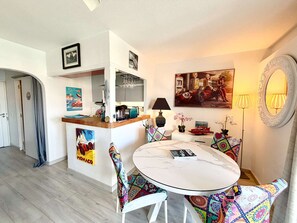 A compact living space with a dining area, kitchen, and a small bar. - Bright apartment with loggia, wifi - Port Grimaud (Port Grimaud)