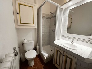 Un baño con inodoro, ducha y lavamanos.