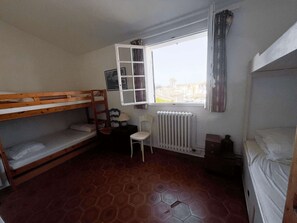 A dormitory room with bunk beds, a radiator, a chair, and a window with curtains. - Fisherman house with parking - marina view (Port Grimaud)