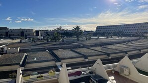 Terraço no telhado com vários níveis, aparelhos de ar condicionado e plantas em vasos.