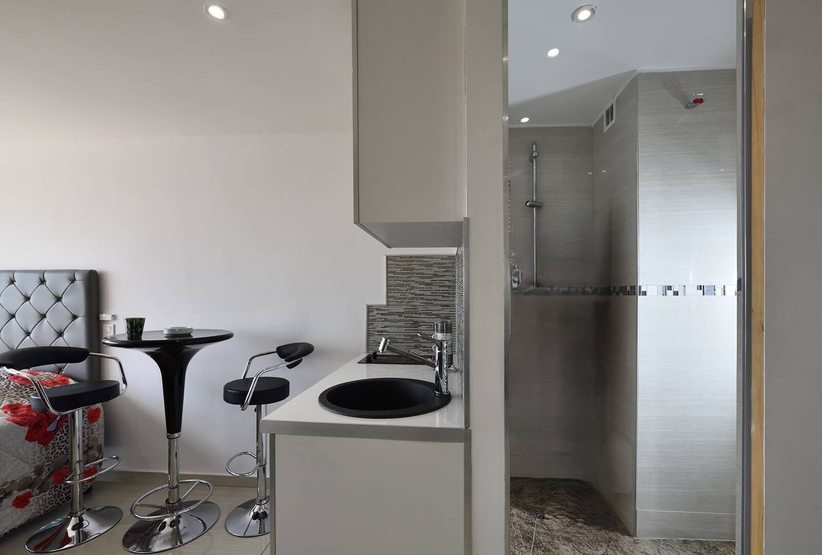 A modern bathroom with a large mirror, a sink, and a shower.