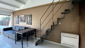 Ein zeitgemäßer Wohnraum mit Treppe, Essbereich und Kunstwerken an den Wänden.