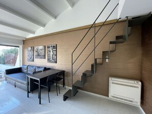 A modern living space with a staircase, a dining area, and artwork on the walls. - MONEYPENNY  - Villa Héliovillage HV 107 - Luxe - 4 people (AGDE)