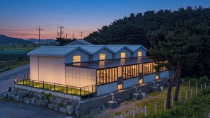 A modern building with a flat roof, large windows, and a balcony area.
