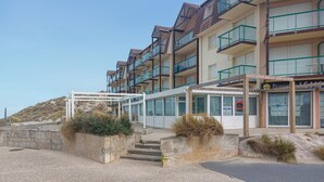 A multi-story hotel with balconies, a beach view, and a beachside location. - Bel appartement vue mer (Camiers)