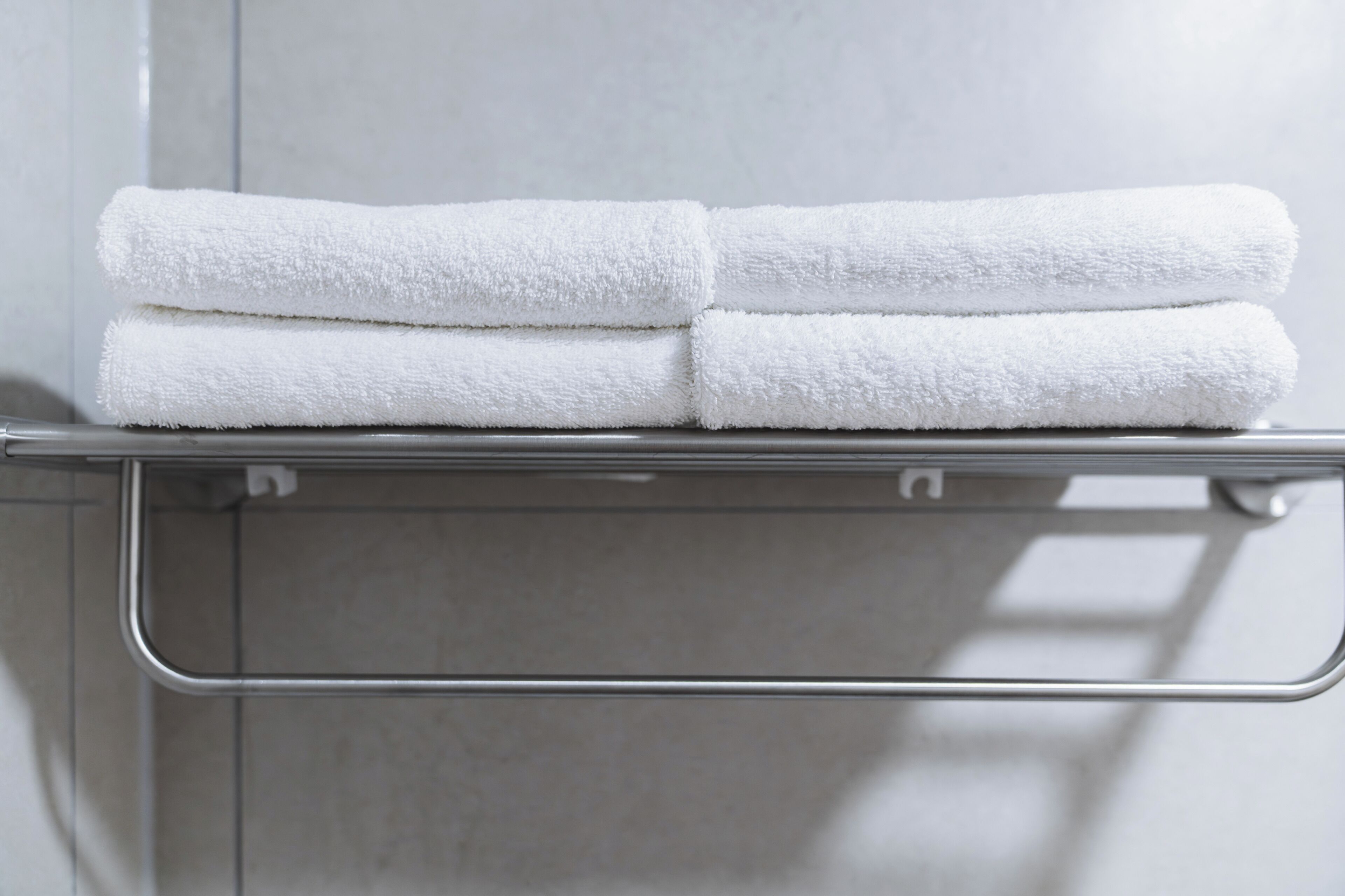 A metal towel rack with two neatly folded white towels.