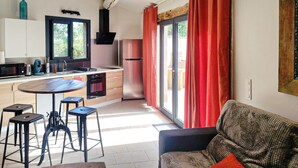 A modern kitchen with a dining area, a sofa, and a table with stools. - Pet friendly home in Monieux (Monieux)