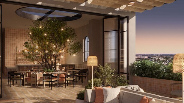 Un espace de restauration en plein air avec un arbre, des tables et des chaises, un canapé et une vue sur la ville.