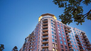 Un edificio de gran altura con un llamativo letrero de 'WYNDHAM' en la parte superior, que cuenta con varios balcones y fachada de ladrillo.