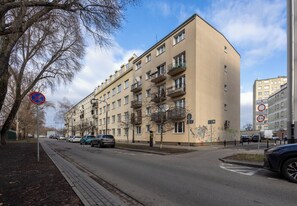 A multi-story residential building with balconies, a no parking sign, and a no U-turn sign. - Royal Baths Superior Apartment (Warszawa)
