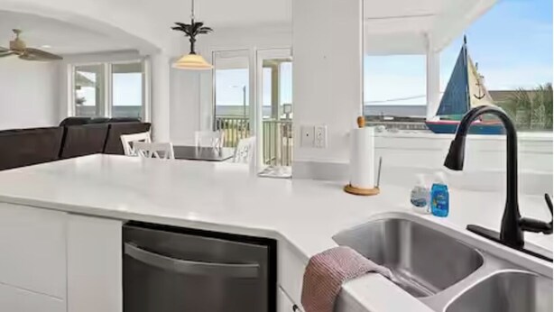 A modern kitchen with a large island, a built-in dishwasher, and a view of the sea. - 4-Bedroom Villa in Flagler Beach with priority beach access (Flagler Beach)
