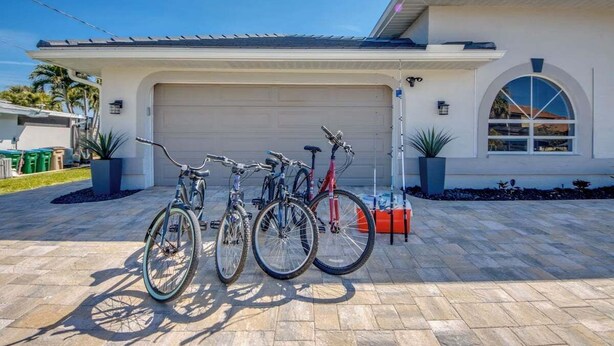 Uma casa moderna com garagem, duas bicicletas e uma entrada bem cuidada.