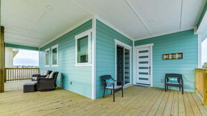 A covered porch with teal siding, two wicker chairs, and a 'WELCOME' sign. - Spacious 4-bedroom house, with boat parking!!!Close to a boat ramp (Rockport)