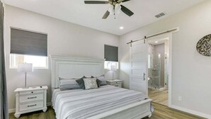 A bedroom with a bed, nightstands, a ceiling fan, and a walk-in closet. - Spacious 4-bedroom house, with boat parking!!!Close to a boat ramp (Rockport)