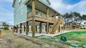 A two-story house with a wooden deck and a staircase leading to the second floor. - Spacious 4-bedroom house, with boat parking!!!Close to a boat ramp (Rockport)