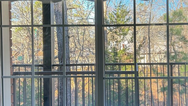 A window with a view of trees and a fence. - Eureka studio unit 401· Jetted tub · Walk downtown (Eureka Springs)