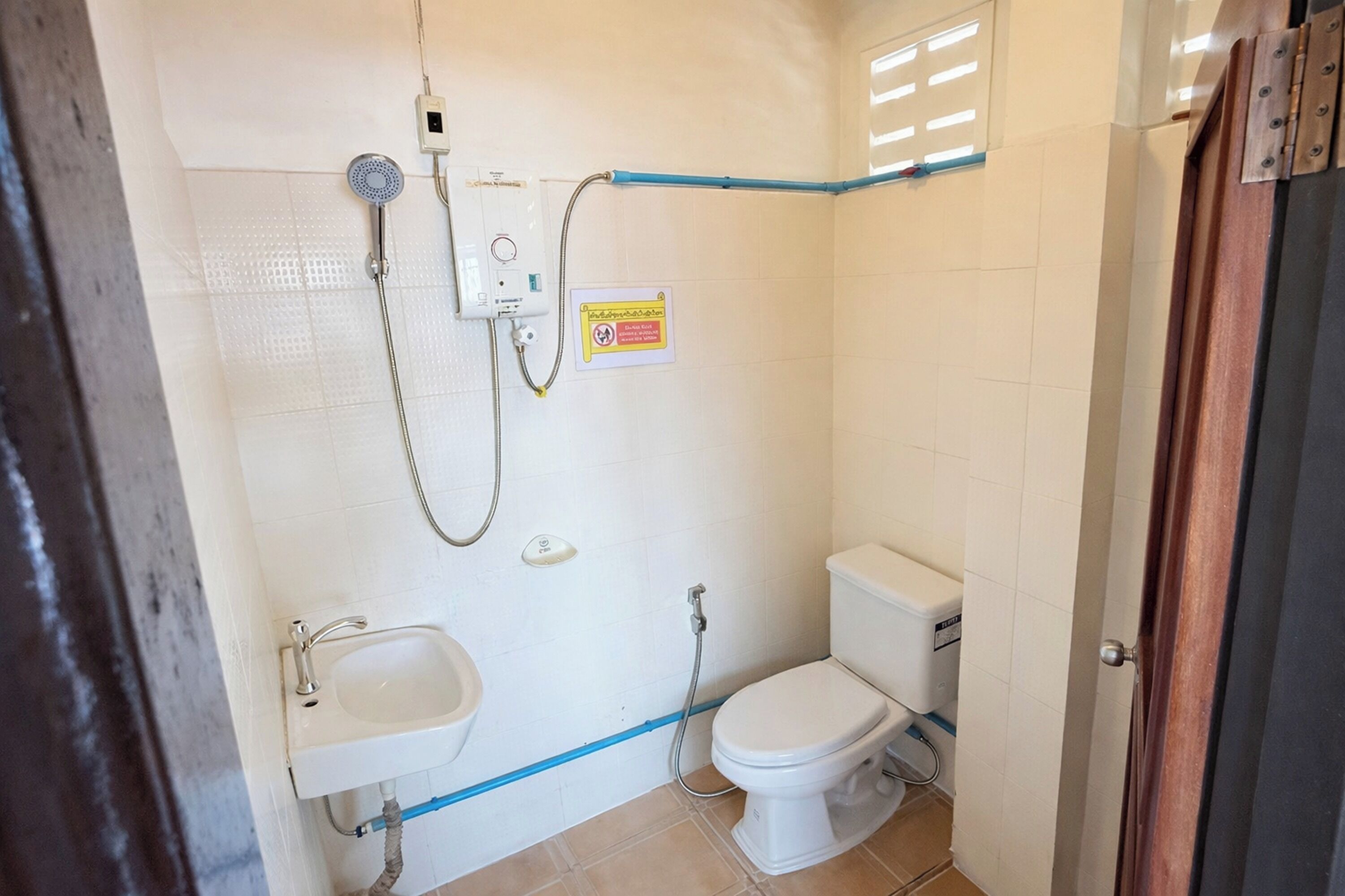 A bathroom with a toilet, sink, and shower.