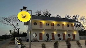 A two-story motel with a yellow sign, multiple balconies, and a well-lit entrance. - The 9 Motel (Ngao)
