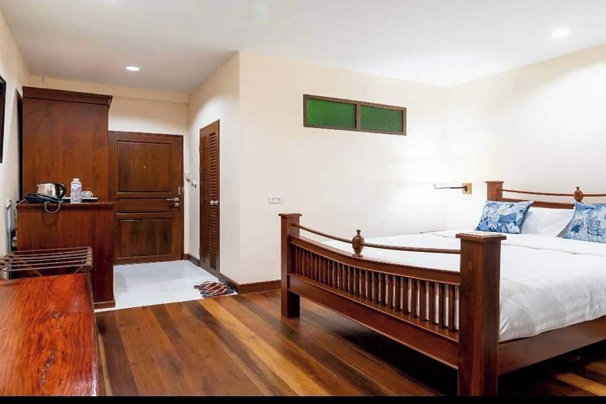 Ein Schlafzimmer mit einem hölzernen Bett, einem Schrank und einem kleinen Tisch.