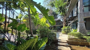 A courtyard with a water feature, stone steps, and lush tropical plants. - Maerim Creek Resort Chiangmai (Mae Rim)