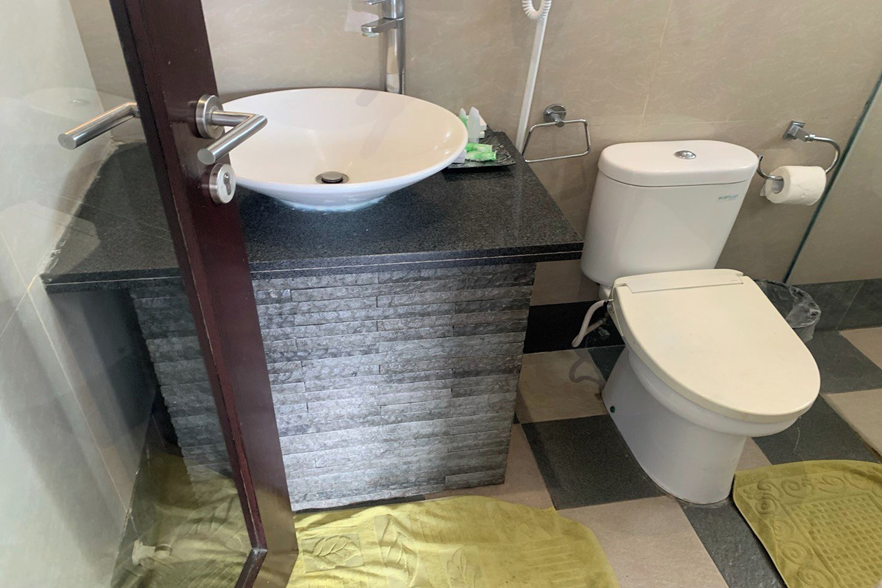 A bathroom with a white sink, toilet, and a towel rack.