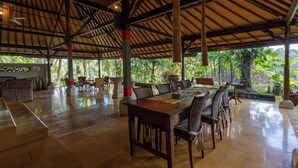Zona pranzo open space con soffitto alto e luce naturale.