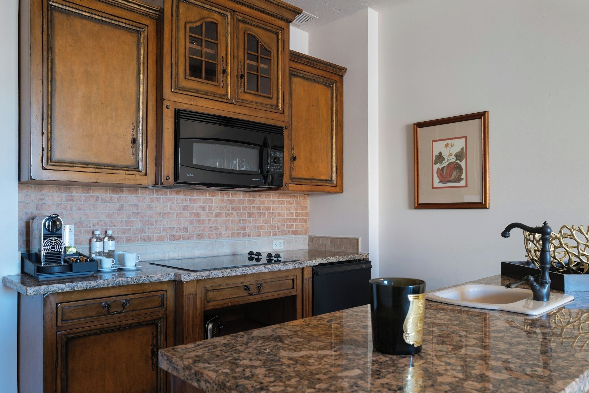 A kitchen with wooden cabinets, a microwave, a sink, and a coffee maker.