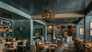 Eine großzügige Bibliothek mit Bücherregalen, ein Essbereich mit Tischen und Stühlen sowie eine große Chandelier.