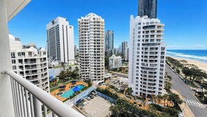 A high-rise hotel with multiple balconies, a swimming pool, and a beach view. - Beachside Ocean View 1BR Apartment Central Surfers (Surfers Paradise)