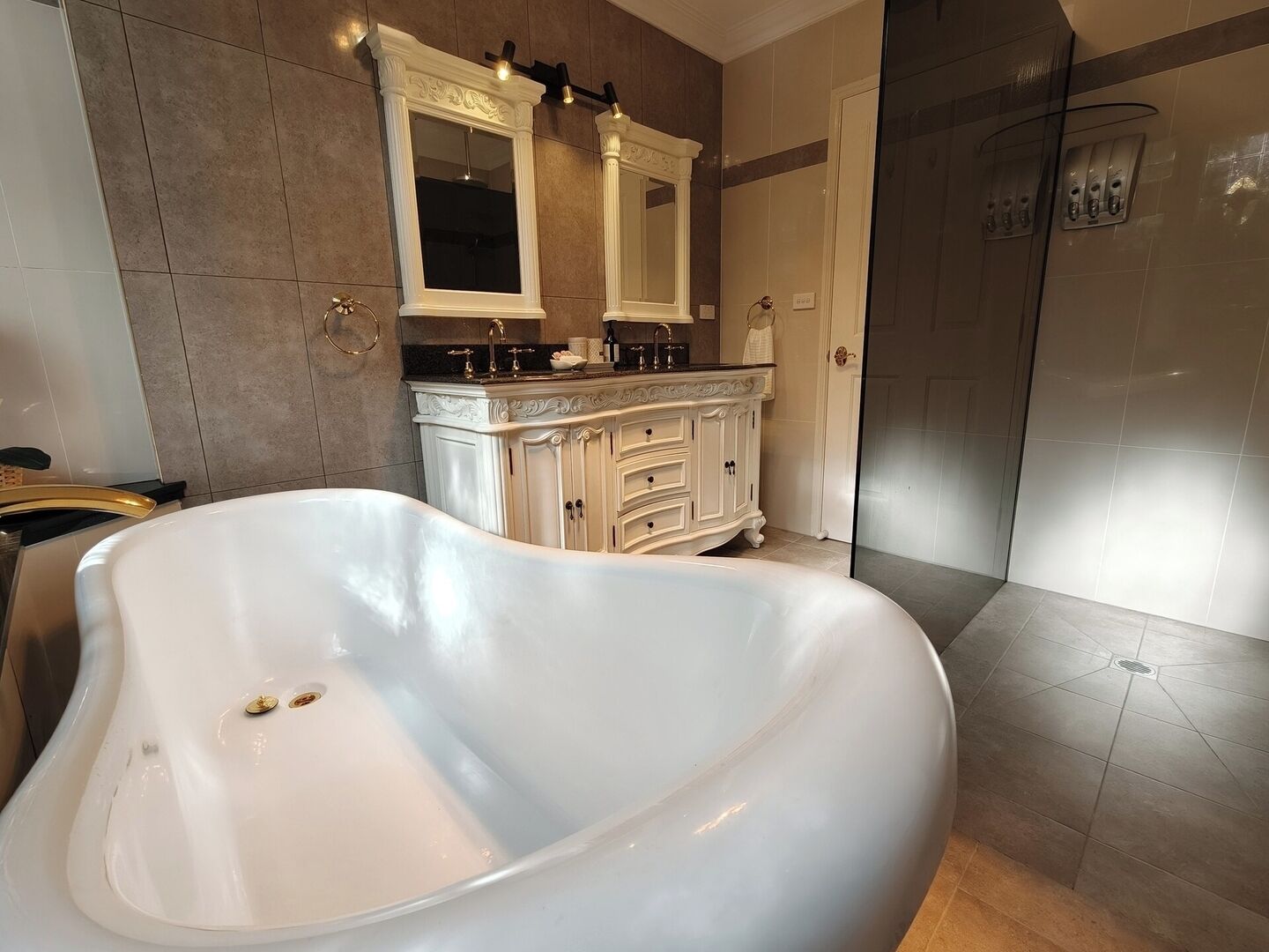 Ein modernes Badezimmer mit freistehender Badewanne, einem Waschtisch mit Spiegel und einer Duschkabine.