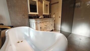 Ein modernes Badezimmer mit freistehender Badewanne, einem Waschtisch mit Spiegel und einer Duschkabine.