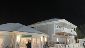 Un edificio de dos pisos con un acceso cubierto identificado con el letrero "Ski & Snowboard Return".