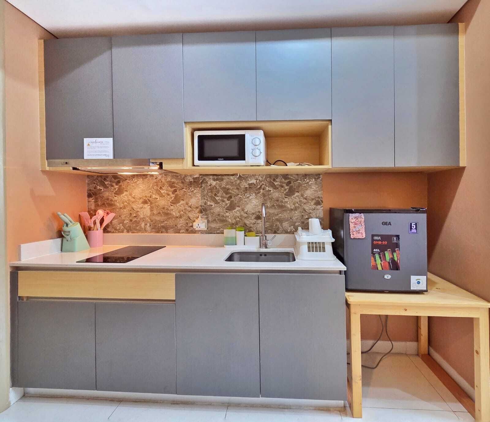 Eine kleine Küche mit Mikrowelle, Spüle und Kühlschrank.