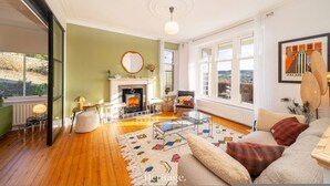 A cozy living room with a fireplace, comfortable seating, and large windows offering a view of the outdoors. - Killiegowan Self-catering Holiday Home in Aberdeen (Aberdeen)