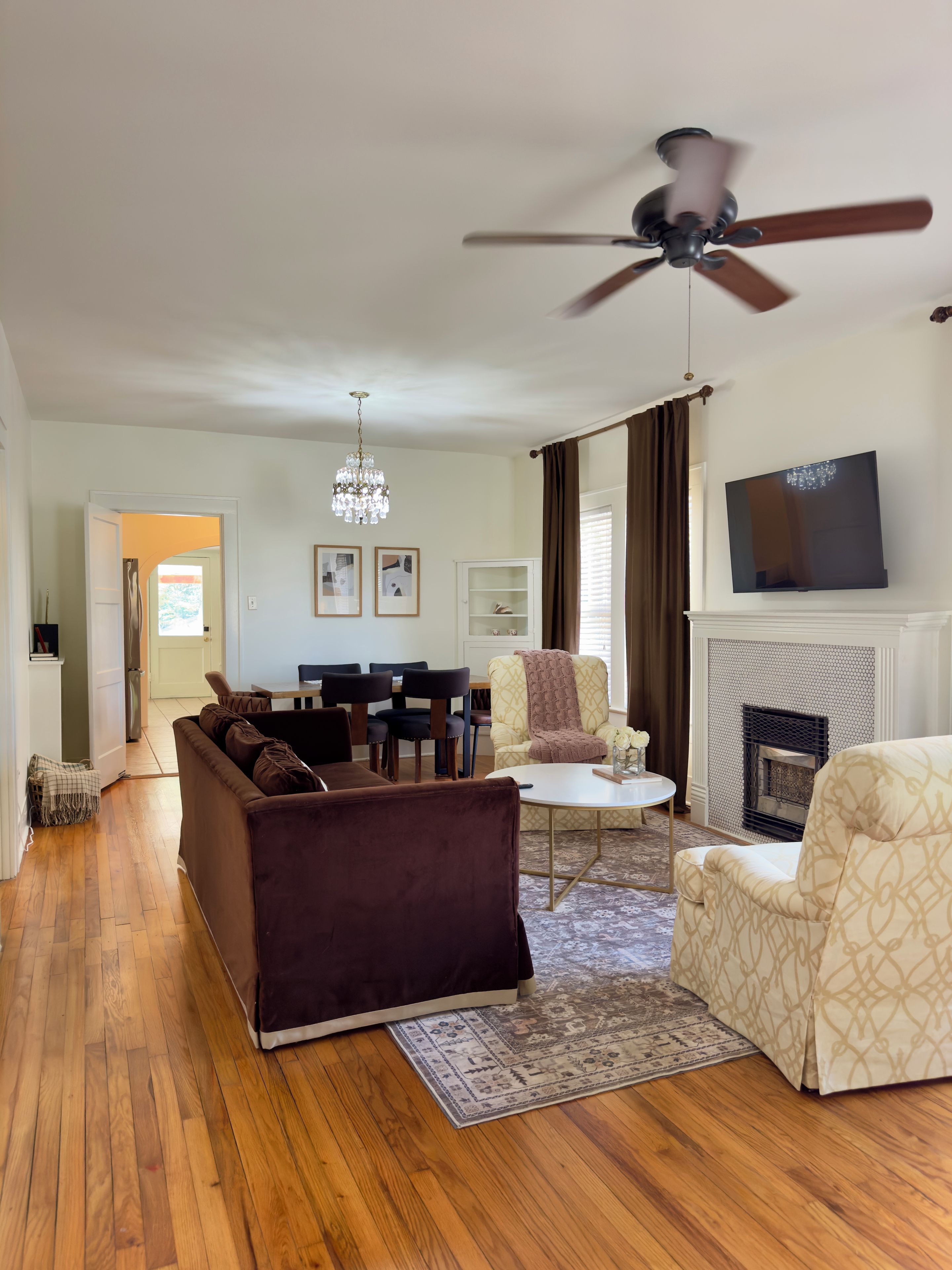 Una sala de estar con sofá, sillón y chimenea.