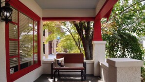 Un portico con una panchina, una lampada e vista sulla strada.
