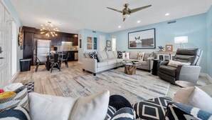 A modern living room with a sofa, coffee table, and a dining area with chairs and a table. - Updated 2 Bed 2 Bath Condo on beautiful Lake Hamilton 7 minutes from Oaklawn!! (Lake Hamilton)
