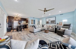 A modern living room with a sofa, coffee table, and a dining area with chairs and a table. - Updated 2 Bed 2 Bath Condo on beautiful Lake Hamilton 7 minutes from Oaklawn!! (Lake Hamilton)