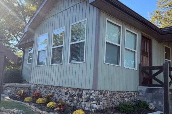 A single-story house with a stone foundation and a light gray exterior. - Small Cozy home just down the road from downtown Guntersville! (Guntersville)
