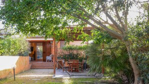Une maison dotée d’un patio couvert, d’un espace salon extérieur et d’un jardin.