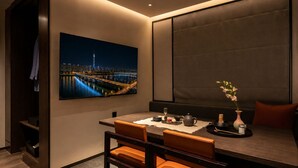 A modern dining area with a cityscape view, a table set with a teapot, and a vase with flowers. - Loop Seoul Hotel by Anook Seoul Gangnam 1 (Seoul)