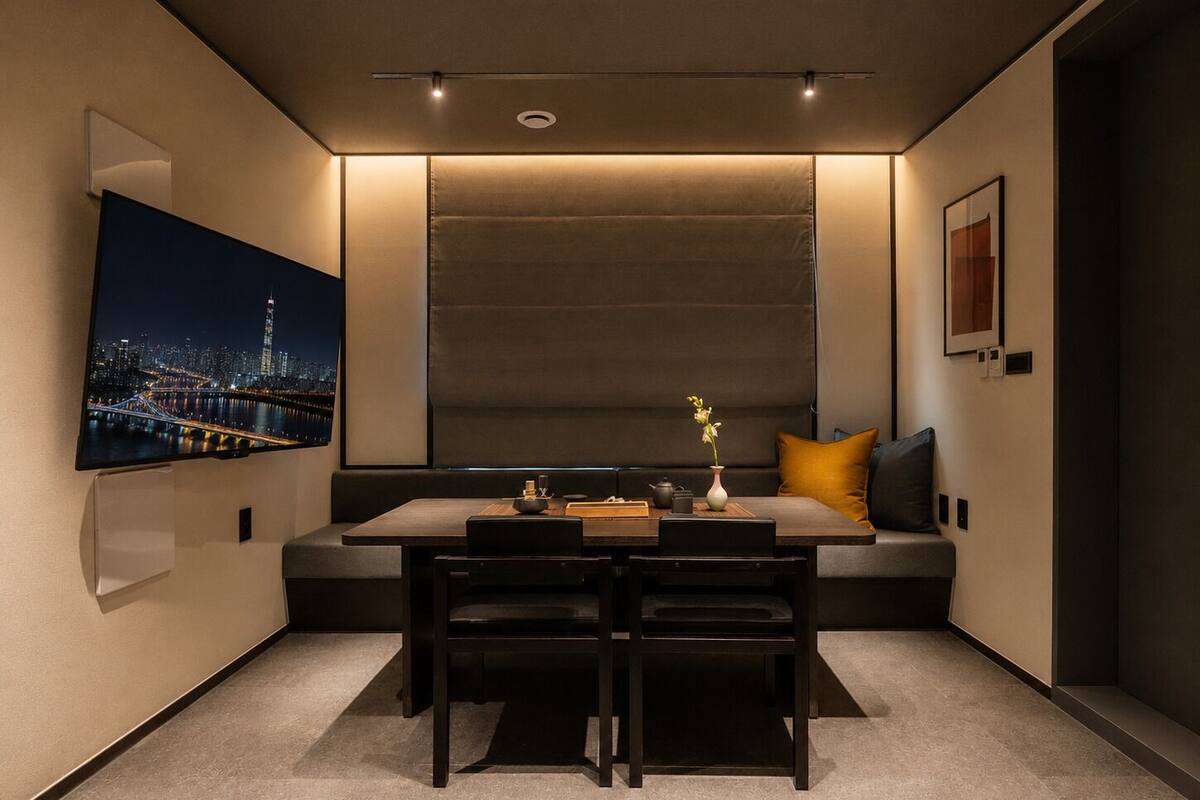 A modern room with a dining table, chairs, a sofa, and a large window.