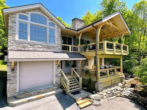 A two-story stone house with a garage, a covered porch, and a balcony with outdoor seating. - Amazing Sunset View, 1 Mile To Ski & Golf, Sauna, Hot Tub, Wi-Fi, Game Room (Beech Mountain)
