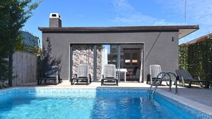 A modern outdoor pool area with a clear blue pool, lounge chairs, and a covered patio. - Studio mit Klimaanlage und Pool (Valbandon)