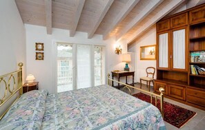 A bedroom with a bed, a desk, a chair, a wardrobe, and a window. - Beautiful apartment in Casarza Ligure with WiFi (Casarza Ligure)