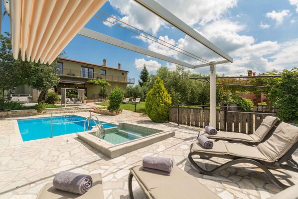 A pool area with lounge chairs and a pergola. - Villa mit Klimaanlage und Pool (Vižinada)