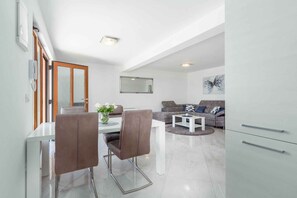 Un salon moderne comprenant un canapé, une table basse et un coin repas avec des chaises et une table.