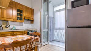 Une cuisine avec des meubles en bois, une cuisinière en acier inoxydable et un réfrigérateur Hisense.