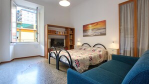 Une chambre à coucher avec un lit, une bibliothèque, un tableau et une fenêtre.